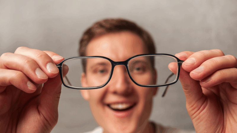 homem tirando óculos de grau (cirurgia de miopia)